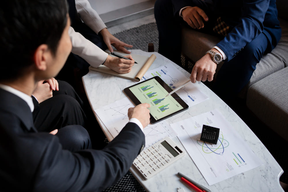 Группа специалистов анализирует финансовые показатели инвестиционного объекта на планшете