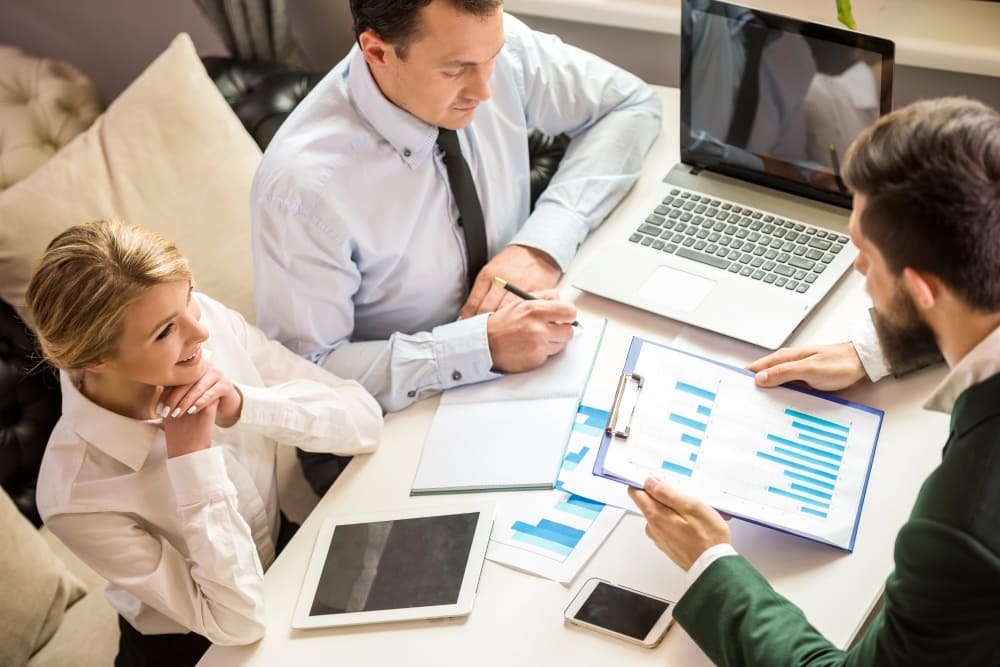 Финансовый консультант обсуждает отчет по доходности недвижимости с Клиентами