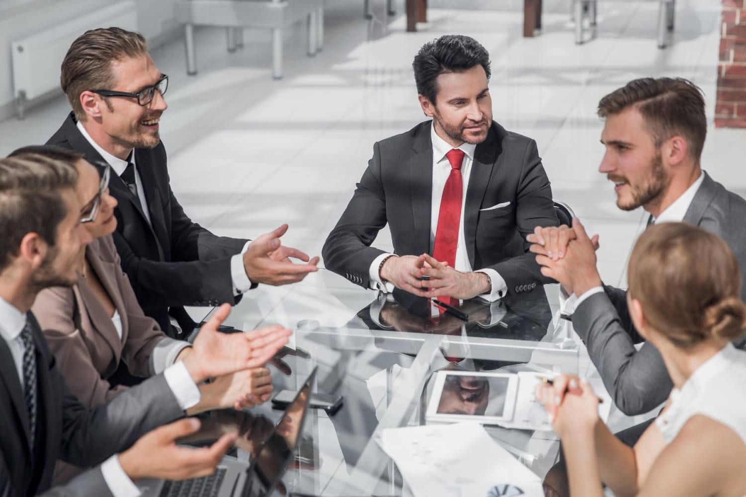 Группа деловых людей ведёт активную дискуссию за столом переговоров