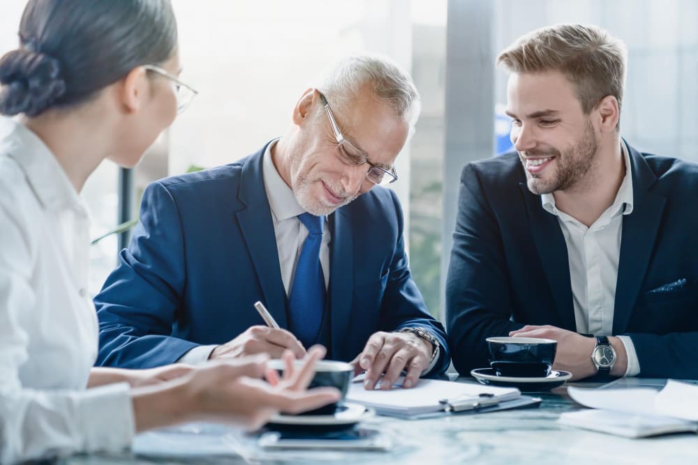 Подписание документов между клиентом и юристом в присутствии консультанта